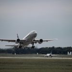 A commercial airplane taking off from Munich Airport on a cloudy day, showcasing aviation dynamics.